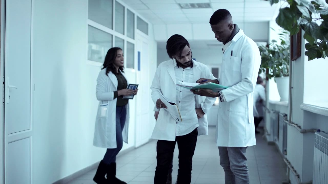 Clinical staff reviewing charts together in a hallway